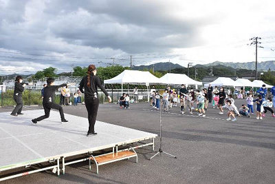 舞台の上で忍者が色々なポーズを取り、それを参加者がみんなで真似をする「みんなで忍者道場」の写真