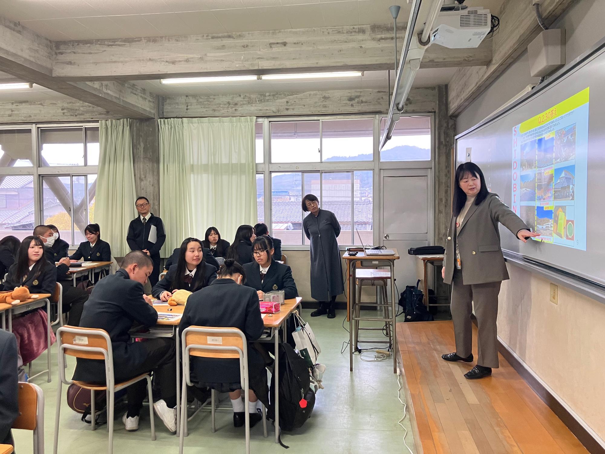 志度高校にて教壇で生徒に説明を行う女性の写真