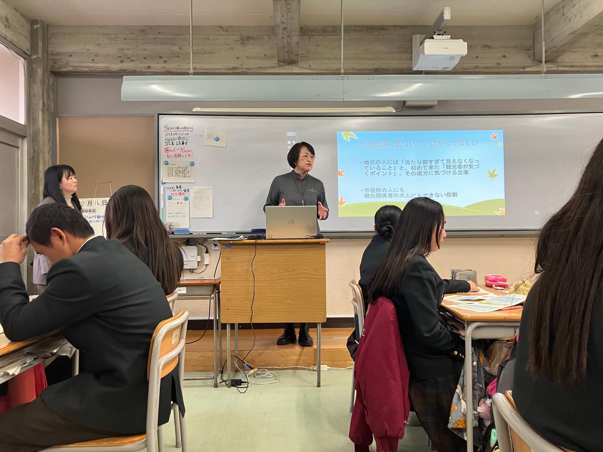 志度高校にて教壇で生徒に説明を行う女性の写真