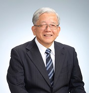眼鏡をかけたスーツ姿の男性が微笑んでいる写真