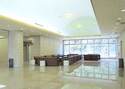 奥がガラスになっている広いロビーに長椅子が置かれている写真