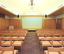 祭壇の手前に参加者用の椅子が大量に並べられている式場の写真