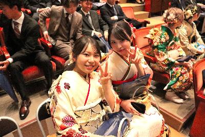 会場内の席に座りながらピースする2名の振り袖姿の女性