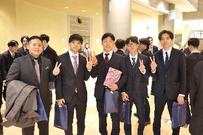 ピースをする4名のスーツ姿の男性