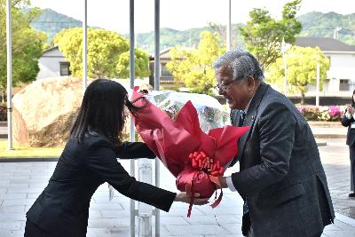 庁舎正面玄関前で職員から花束を受け取る大山市長