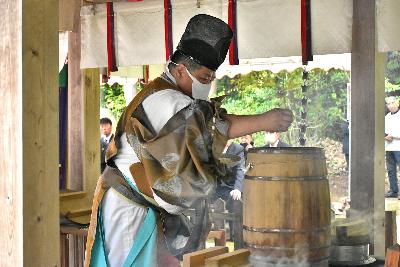 神職が釜の上の甑に洗米を入れる様子