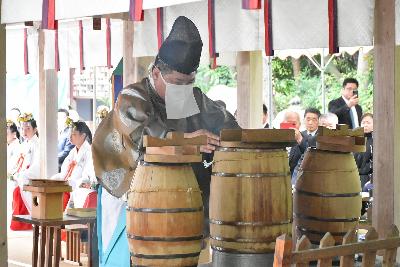神職が甑の上の蓋をずらし、音が響き渡る様子