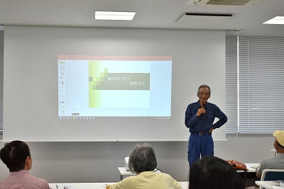 着席した人たちの前で男性が話している写真