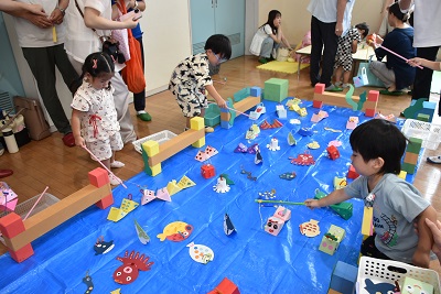 手作りの魚を釣り上げて遊ぶ子どもたち
