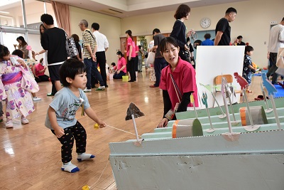 先生と一緒にくじびきを引く子ども