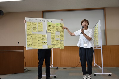 たくさんの意見が書き込まれた模造紙を使って発表する参加者