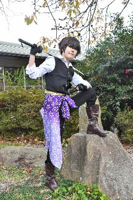 岩の上に足を乗せ刀を肩に担ぐコスプレイヤー