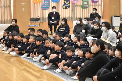 体育座りをして話を聞く園児と保護者