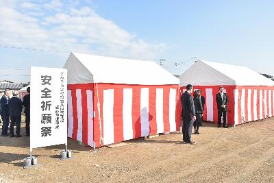 安全祈願祭の看板とテントの周辺でスーツ姿の男女が話している様子
