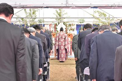 宮司とスーツ姿の関係者が祭壇に拝礼する様子