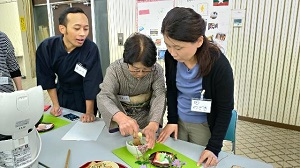 先生に教えられながら茶道体験をする参加者たちの写真