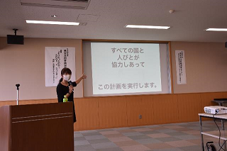 スクリーンに「すべての国と人びとが協力しあってこの計画を実行します。」と映された講義シーンの写真