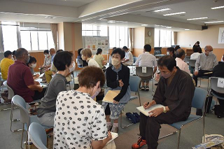 参加者たちが向かい合ってグループワークに取り組んでいる写真