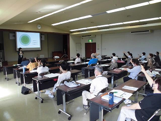 男女共同参画講座2022でアンケートに各々手をあげる参加者たちの写真