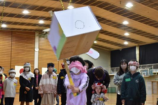 目隠しをしてダンボールでできたくす玉を割るピニャータを楽しんでいる写真