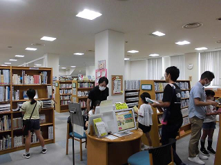 令和5年9月30日に開催した男女共同参画セミナー「図書館かしきり！お父さんといっしょにたんていになろう！」の参加者が図書を探している様子の写真