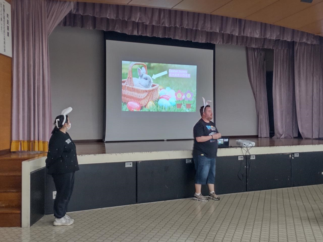 ALTといっしょにEaster Party！2024で、講師の先生方が大きなスクリーンの前で挨拶をしている写真