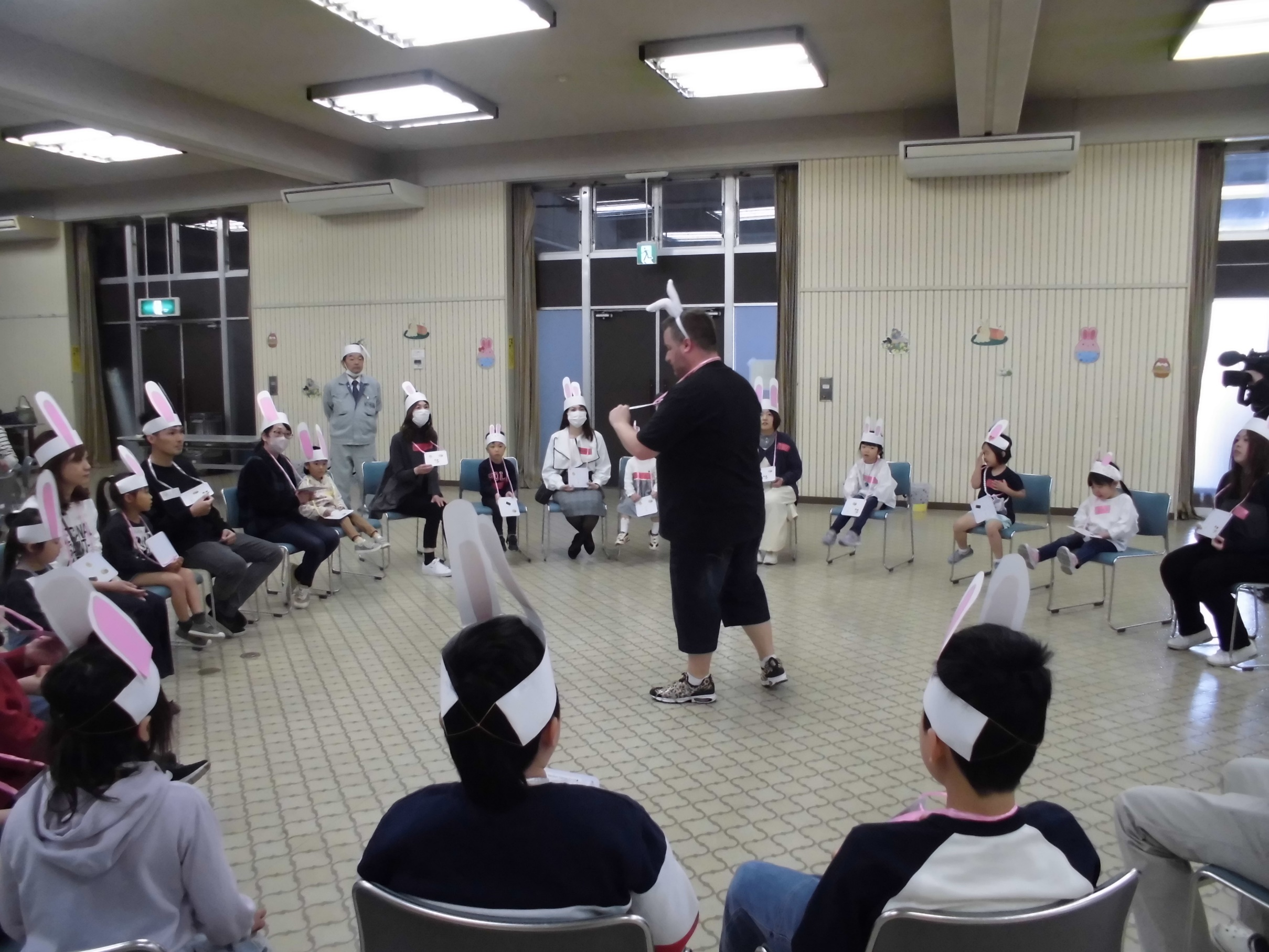 バニーヘッドバンドを頭にかぶり、円形に並べられた椅子に座って講師の話に耳を傾ける参加者たちの写真