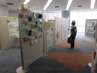 ポスター展示のエリアで展示されたポスターを見てる訪問者たちの写真