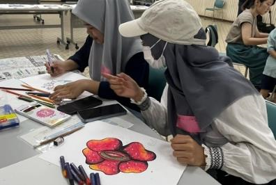 参加者がラフレシアのような大きな赤い花を描いている写真