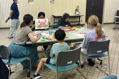 猿蟹合戦の絵本のようなものを広げてコミュニケーションを取るグループの写真