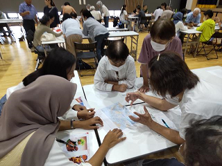 参加者たちがテーブルで地図のような資料を囲んで話し合うグループワークの写真