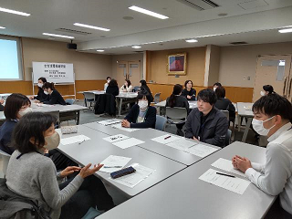 参加者がテーブルを囲み、数名ごとに分かれて意見交換を行っている写真