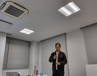 男性講師が身振り手振りを交えながら参加者に話している写真