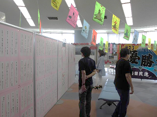 多くの川柳や俳句が展示されたブースで、来場者が作品を眺めている写真