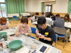 男性と女性参加者が絵付けに取り組んでいる写真