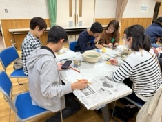 スマホで確認したり、隣同士で相談したりしながら各々の方法で作業を進めている参加者たちの写真