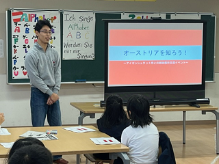 令和6年11月5日（火曜日）に開催された「オーストリアの子どもたちに手紙を書こう」で講師の男性が参加児童たちに説明をしている写真