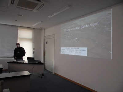 令和7年2月16日（日曜日）に開催された「外国人住民のための防災訓練」でプロジェクターを使って災害について講師が説明している写真