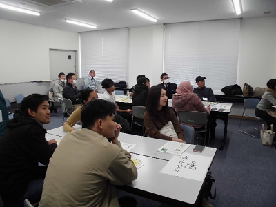 色々な国籍の人が真剣な様子で講師の災害についての説明を聞いている写真