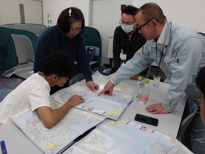 講師の方がサポートしながら地図とハザードマップを照らし合わせ避難方法などを確認している写真