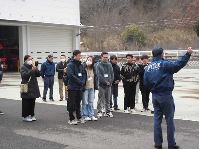 消防署の外に出て、これから行うさまざまな体験について説明を受けている参加者たちの写真