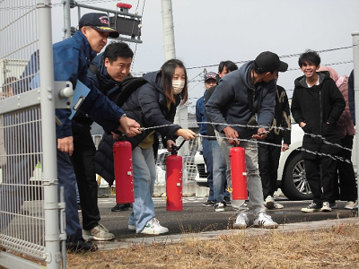 水の入った模擬的な消火栓を使って消化訓練を行う参加者たちの写真
