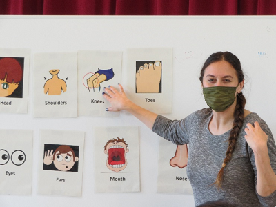 身体の名称が英語で書かれたカードを指さしているモーガン先生の写真