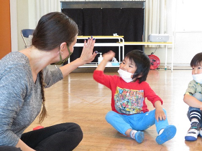 ホールでモーガン・クラリッチ先生と笑顔でハイタッチしている一人の男の子の写真