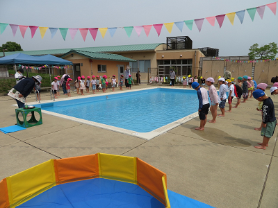 プールサイドで子どもたちが並んでプール開きのあいさつをしている様子の写真