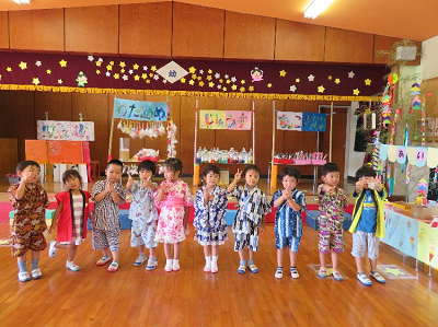 室内で浴衣を着た園児たちが一列に並び様々なポーズをとっている写真