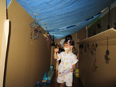 段ボールでできた迷路の中を突き進む園児の写真