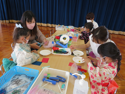 浴衣を着た園児たちが保護者と一緒に工作に取り組む様子の写真