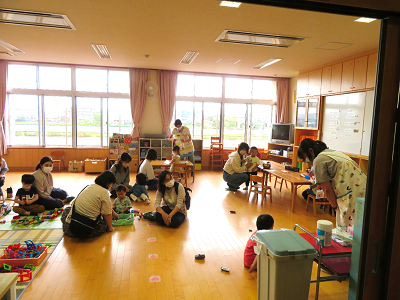 保育室で保護者と一緒に遊ぶ子どもたちの写真