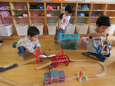 電車のおもちゃで遊ぶ子どもたちの写真